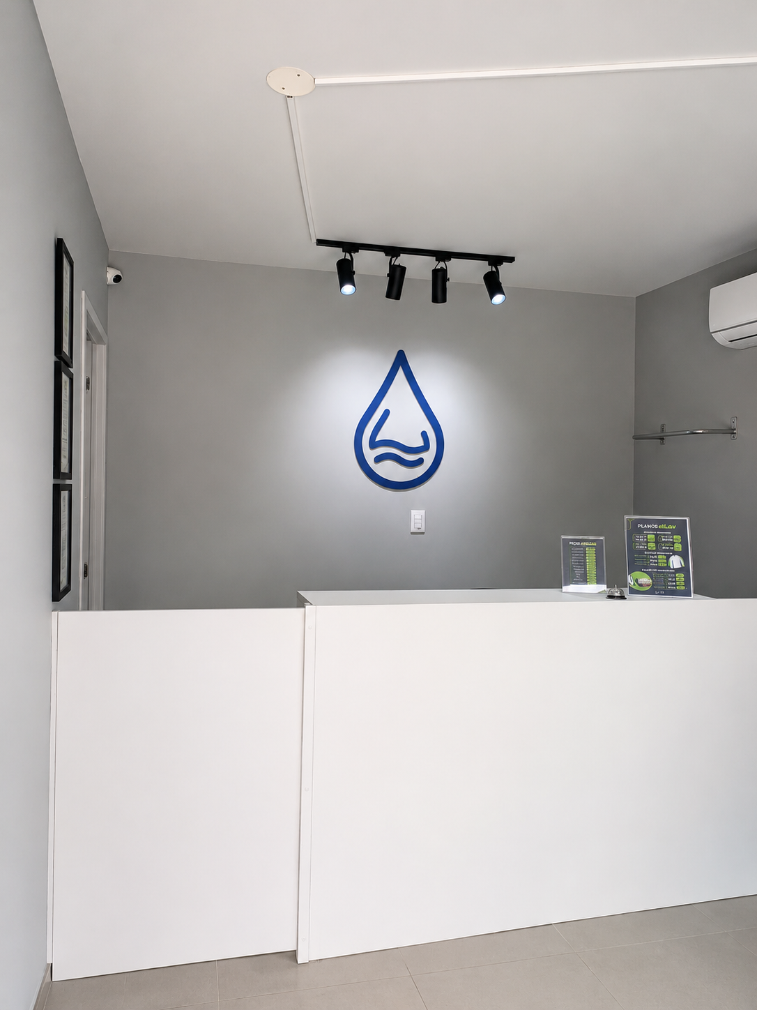 Recepção da eLav Lavanderia Florianópolis com balcão de atendimento e logo iluminada na parede